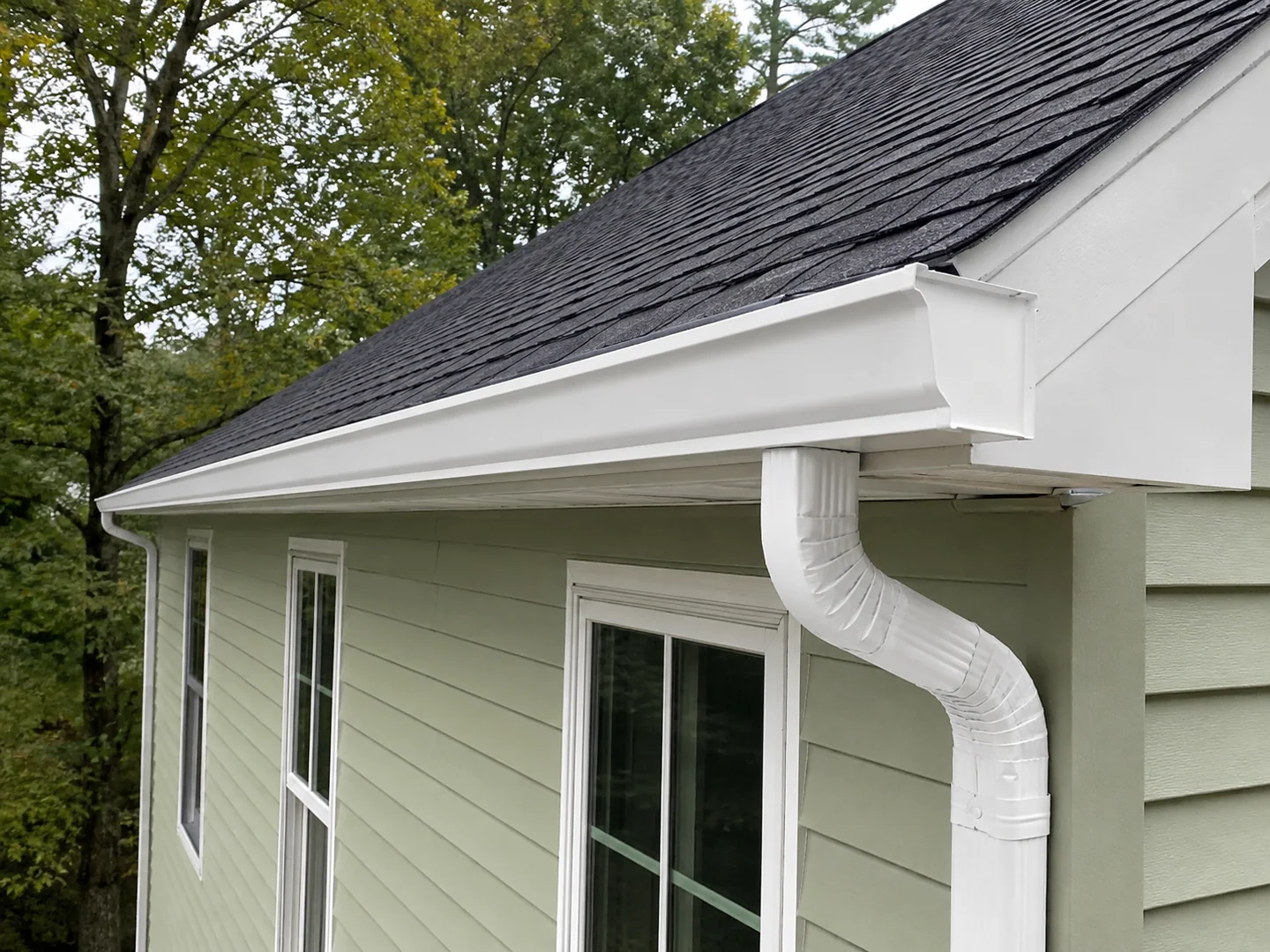 Close seamless gutter and downspout detail on sage residential siding