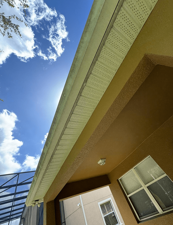 After: gutter secured along the same stucco home's roof edge