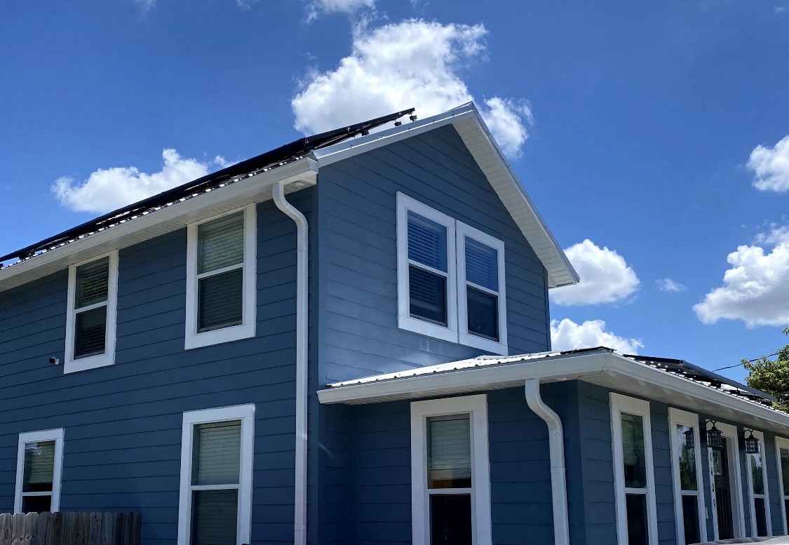 White gutters and downspouts below the roof edge of a blue Pennsylvania home